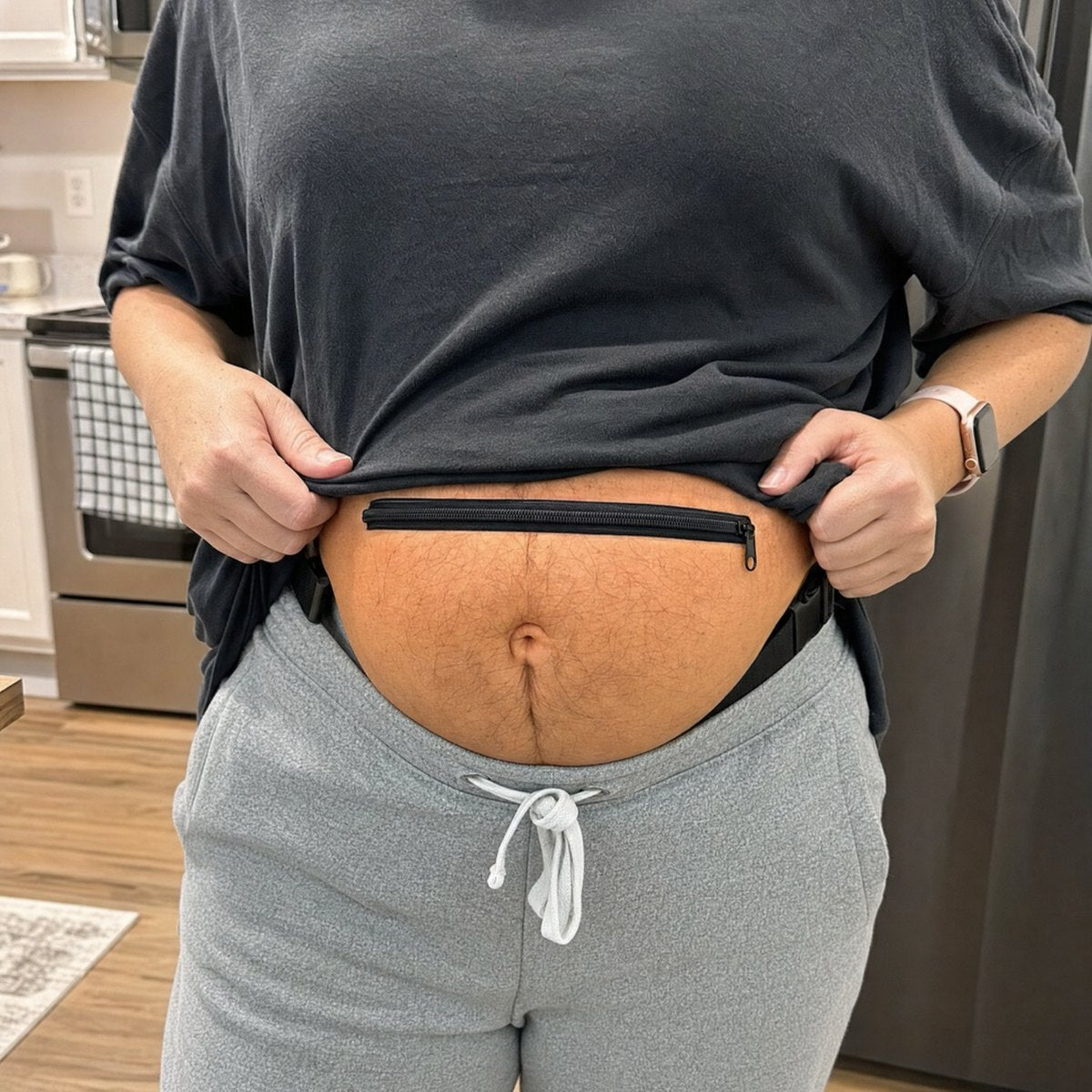 Lifting a shirt to show the belly bag zip across the top